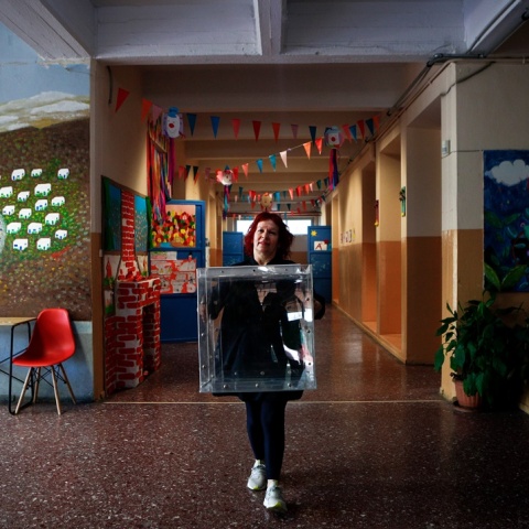 Γυναίκα με κάλπη στα χέρια σε διάδρομο σχολείου