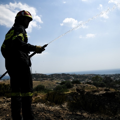 Πυροσβέστης με μάνικα ανά χείρας κατά τη διάρκεια κατάσβεσης
