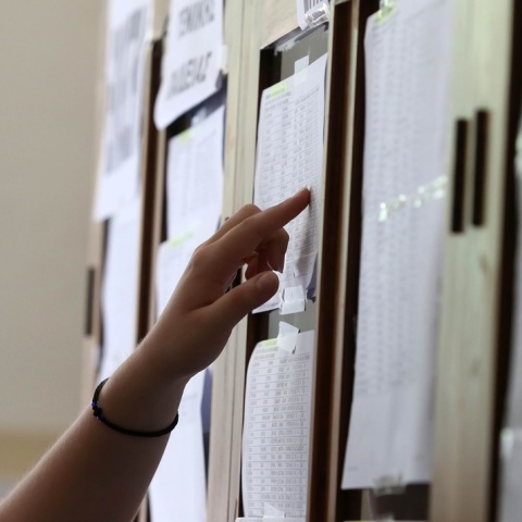 Υποψήφιοι αναζητούν τις βαθμολογίες τους μετά την ανάρτησή τους έξω από σχολείο, όπως γινόταν στο παρελθόνν