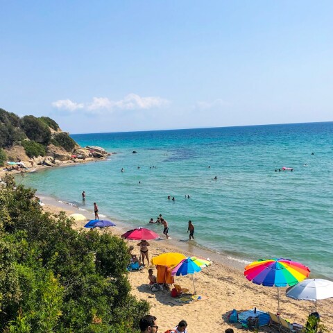 Παραλία στην Ελλάδα και λουόμενοι που απολαμβάνουν το μπάνιο τους