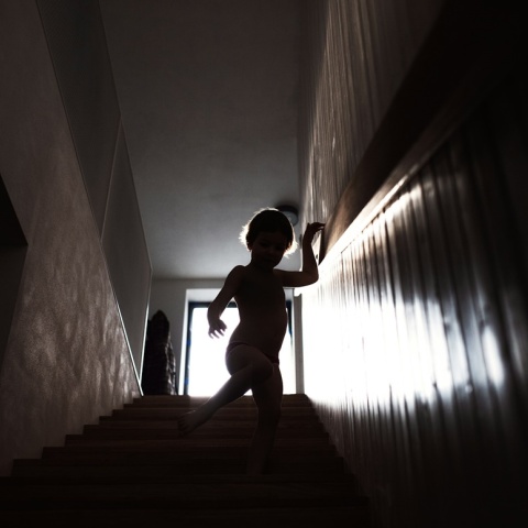 Παιδί κατεβαίνει σκάλες - Φωτογραφία με σκοτεινό φόντο