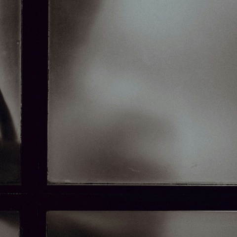 Σκιά ατόμου πίσω από παράθυρο