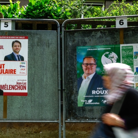 Πολίτες μπροστά από αφίσες εκλογών στη Γαλλία