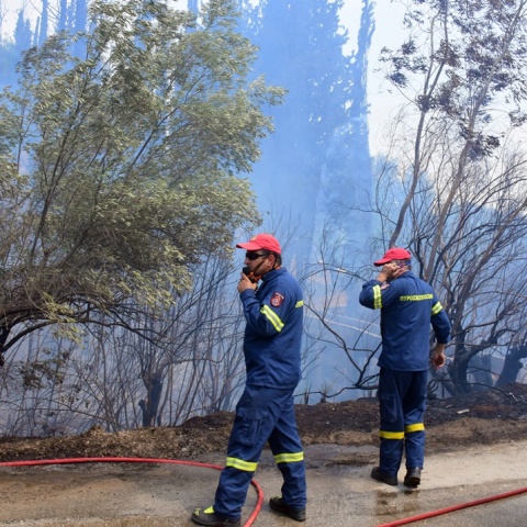 Πυροσβέστες επιχειρούν για την κάτασβεση φωτιάς φορώντας μάσκες