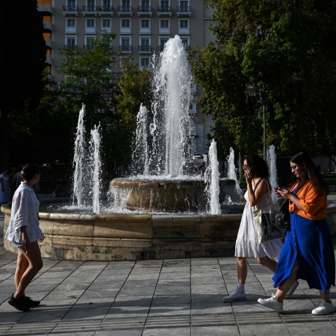 Πολίτες περπατούν στο κέντρο της Αθήνας εν μέσω καύσωνα