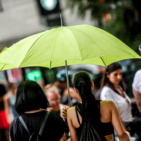 Πολίτες με ομπρέλα προστατεύονται από τη βροχή