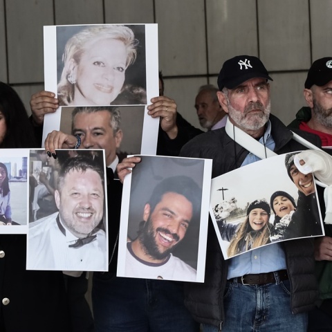 Συγγενείς θυμάτων με τις φωτογραφίες των προσώπων που έχασαν στη φωτιά στο Μάτι ανά χείρας έξω από το δικαστήριο