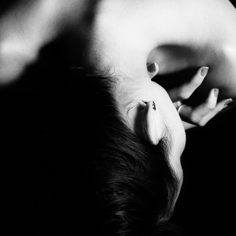 Η πλάτη και ο λαιμός γυναίκας που προστατεύει το μπροστινό μέρος του σώματός της - Μία εικόνα που παραπέμπει σε κακοποίηση