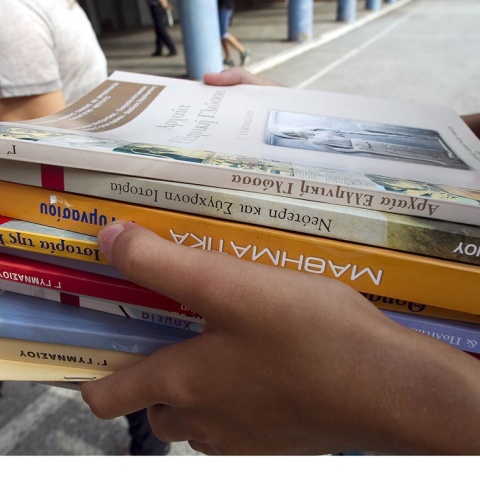 Σχολικά βιβλία στα χέρια μαθητή