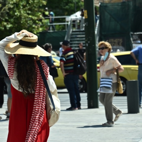Πολίτες περπατούν στο κέντρο της Αθήνας ενόψει καύσωνα