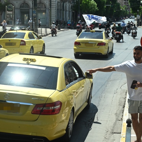 Ταξί και άτομο που σηκώνει το χέρι του για να καλέσει ταξί