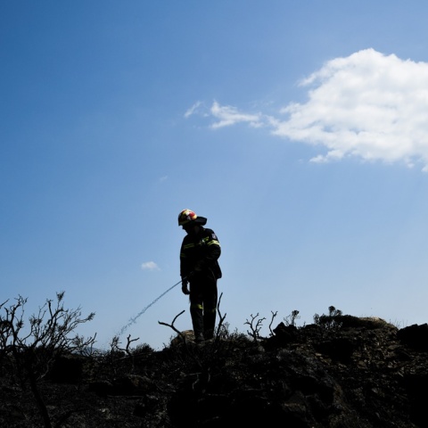 Η σιλουέτα πυροσβέστη διακρίνεται στην κορυφή υψώματος