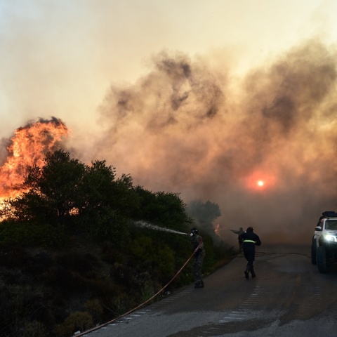Φωτιά σε εξέλιξη και πυροσβέστης που επιχειρεί για την κατάσβεση
