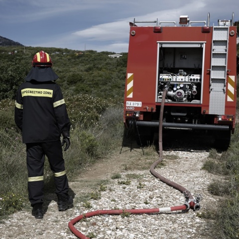 Πυροσβέστης δίπλα από το πυροσβεστικό όχημα
