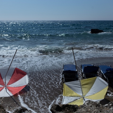 Αναποδογυρισμένες ομπρέλες σε παραλία και έντονος κυματισμός λόγω των μελτεμιών