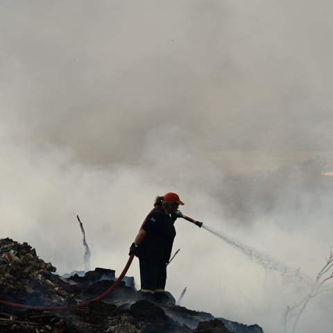 Γυναίκα πυροσβέστης επιχειρεί με τη μάνικα για την κατάσβεση φωτιάς