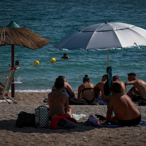 Πολίτες σε παραλία κάτω από ομπρέλα για λίγες στιγμές δροσιάς