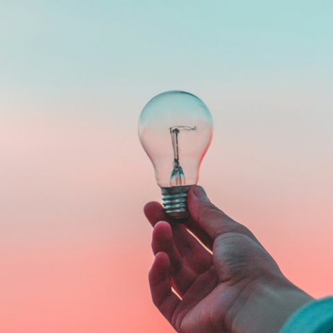 Λάμπα την οποία κρατά ένα χέρι ψηλά με φόντο τον ορίζοντα