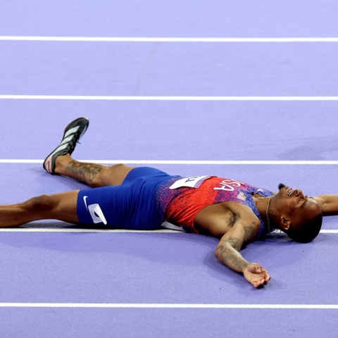 Ο Quincy Hall πανηγυρίζει ξαπλωμένος στον αγωνιστικό χώρο το χρυσό μετάλλιο στα 400 μέτρα στους Ολυμπιακούς Αγώνες 2024 στο Παρίσι