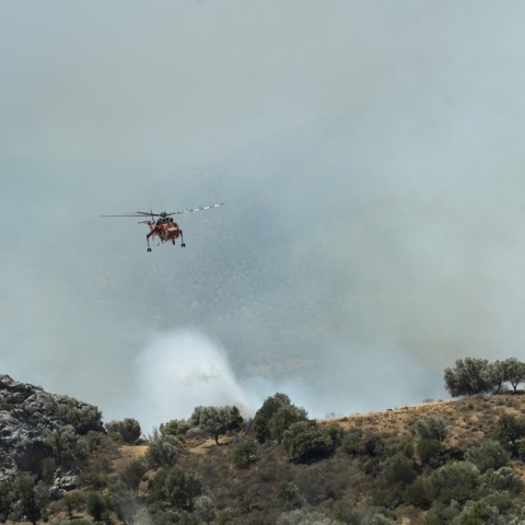 Καπνοί και πυροσβεστικό ελικόπτερο που επιχειρεί στη φωτιά στο Ρέθυμνο