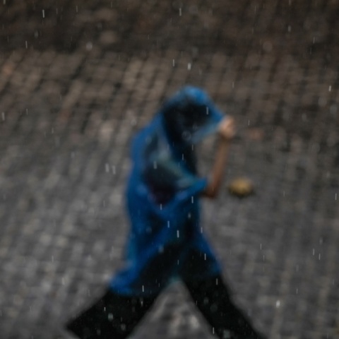 Άτομο με αδιάβροχο προστατεύεται από τη βροχή