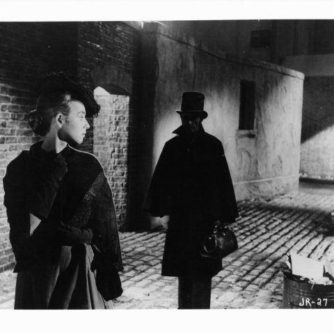 Άγνωστη ηθοποιός κοιτάζει πίσω σε έναν άνδρα που την ακολουθεί σε μια σκηνή από την ταινία «Jack The Ripper», 1959