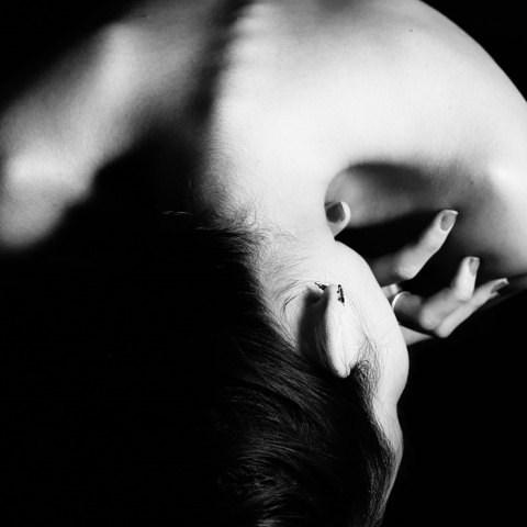 Γυναίκα που κρατά το σώμα της με τα χέρια της σε εμβρυακή στάση - Μια εικόνα που παραπέμπει σε ενδοοικογενειακή βία αφού η γυναίκα φαίνεται σε στάση άμυνας