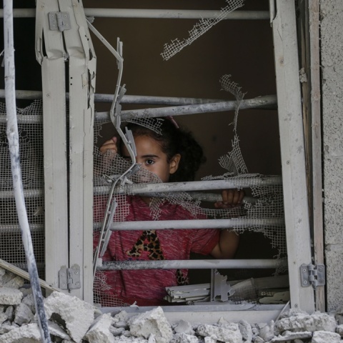 Παιδάκι πίσω από ερείπια σπιτιού στη Γάζα κοιτά τον φωτογραφικό φακό