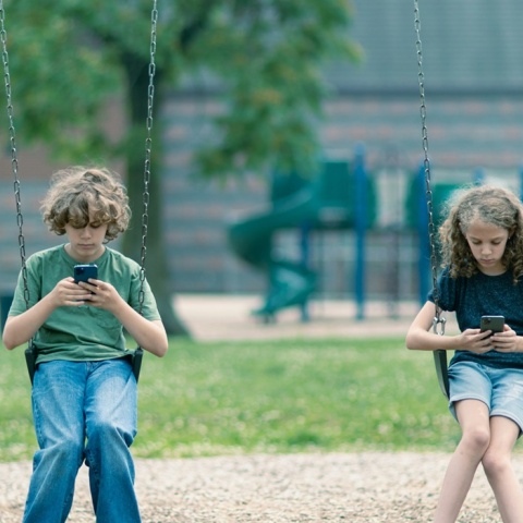 Παιδιά σε κούνια κοιτούν το κινητό τους