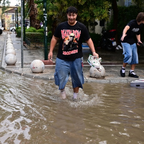 Πολίτης περπατά σε πλημμυρισμένο δρόμο της Αττικής μετά από την ισχυρή καταιγίδα που έφερε η κακοκαιρία Atena