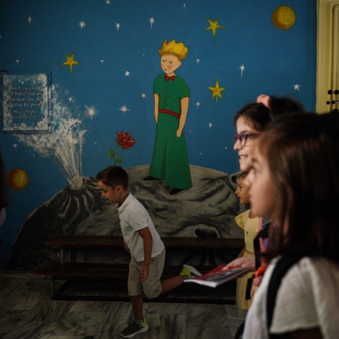 Μαθητές σε σχολείο μπροστά από τοιχογραφία με τον Μικρό Πρίγκιπα