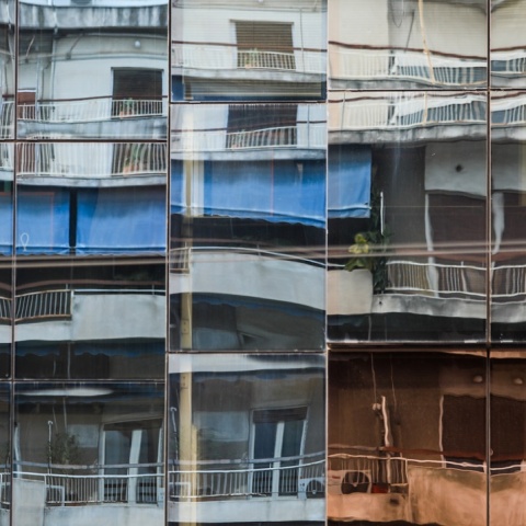 Ο αντικατοπτρισμός μπαλκονιών και κτιρίων σε τζάμια πολυκατοικίας