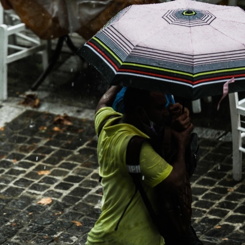 Πολίτες με ομπρέλες προστατεύονται από τη βροχή