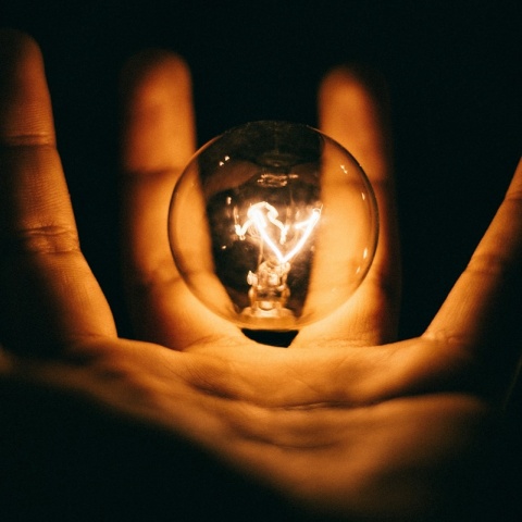 Αναμμένη λάμπα στα χέρια ατόμου