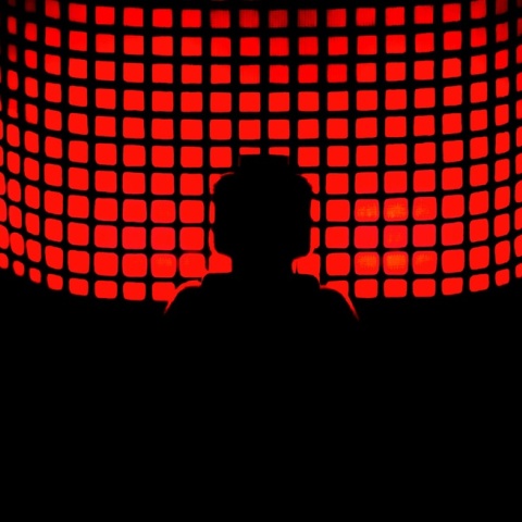 Κεφάλι ατόμου μπροστά σε οθόνη με κόκκινους κύβους