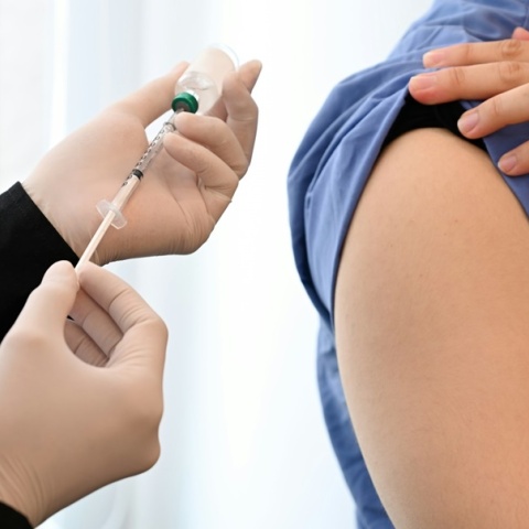 Άτομο επιχειρεί να κάνει εμβόλιο σε άτομο που έχει σηκώσει το μανίκι του