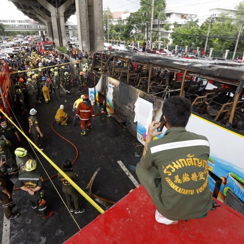 Πυροσβεστικές αρχές της Ταϊλάνδης δίπλα από το καμένο σχολικό λεωφορείο