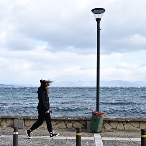 Κρύο και δυνατοί άνεμοι - Γυναίκα που περπατά υπό αυτές τις συνθήκες δίπλα στη θάλασσα