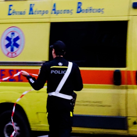 Ασθενοφόρο και τροχονόμος που βάζει κορδέλα σε δρόμο