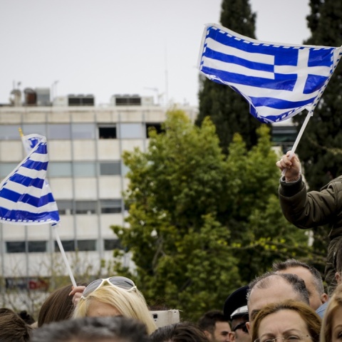 Παιδάκι στους ώμους του μπαμπά του κρατά την ελληνική σημαία