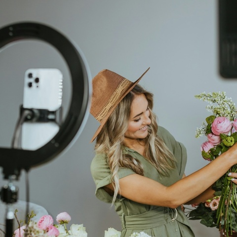 Κοπέλα δείχνει φυτά μπροστά από ring light