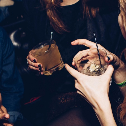 Άτομα σε κλαμπ κρατούν τα ποτήρια με το ποτό τους