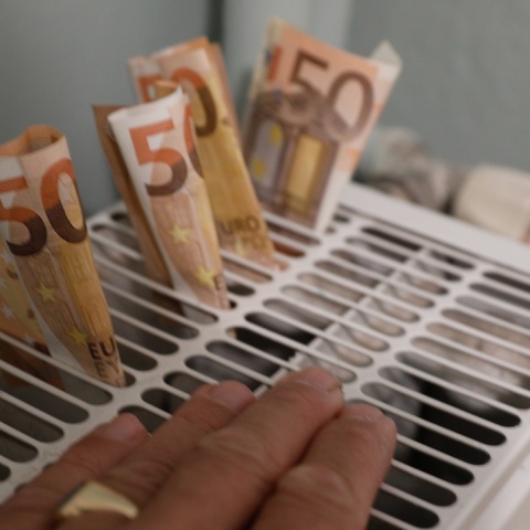 Χέρι και χρήματα πάνω σε καλοριφέρ