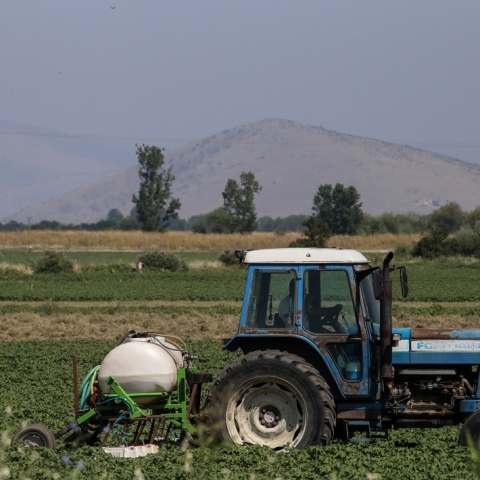 Αγρότης με τρακτέρ σε χωράφι