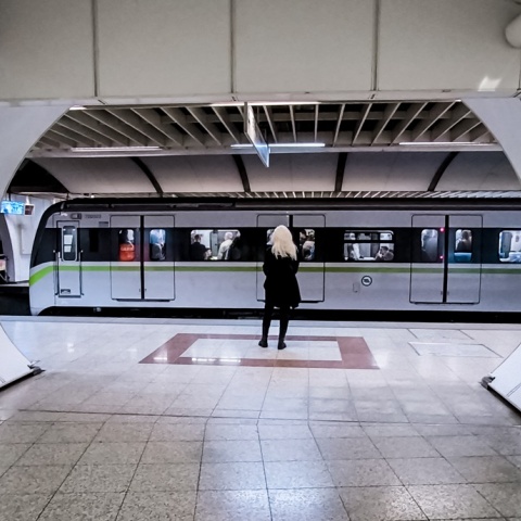 Γυναίκα σε σταθμό του μετρό και πίσω της ένας συρμός