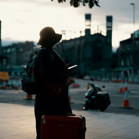 Γυναίκα με βαλίτσα στο χέρι σε ταξιδιωτικό προορισμό