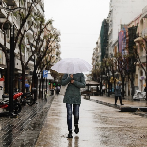 Άτομο με ομπρέλα σε βροχερό δρόμο