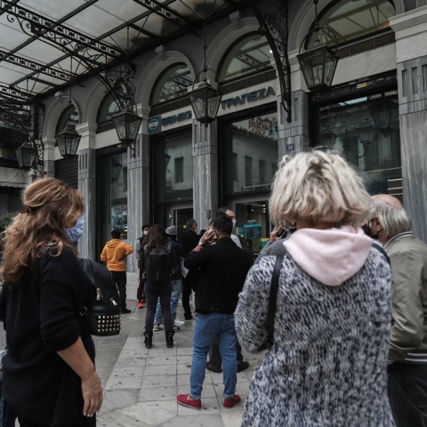 Άτομα περιμένουν σε ουρά για το ΑΤΜ