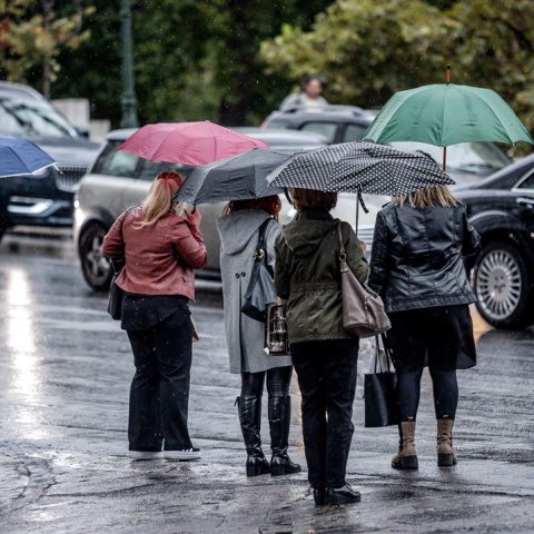 Πολίτες με ομπρέλα προστατεύονται από τις βροχές