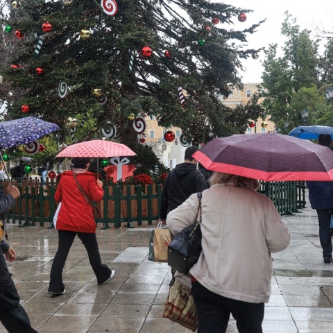 Πολίτες με ομπρέλα κάτω από το χριστουγεννιάτικο δέντρο στο Σύνταγμα